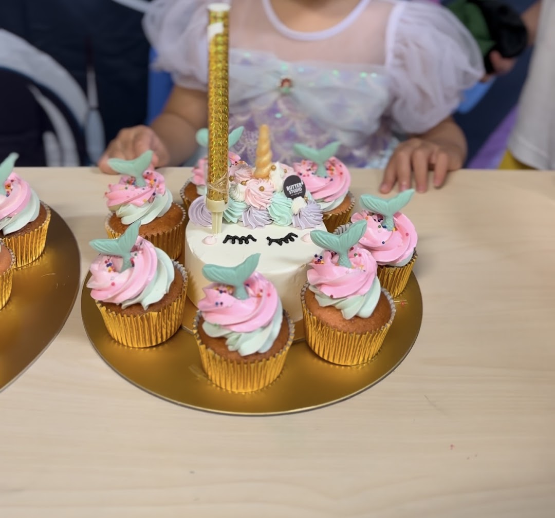 A delightful unicorn cake surrounded by mermaid tail cupcakes, perfect for celebrations.