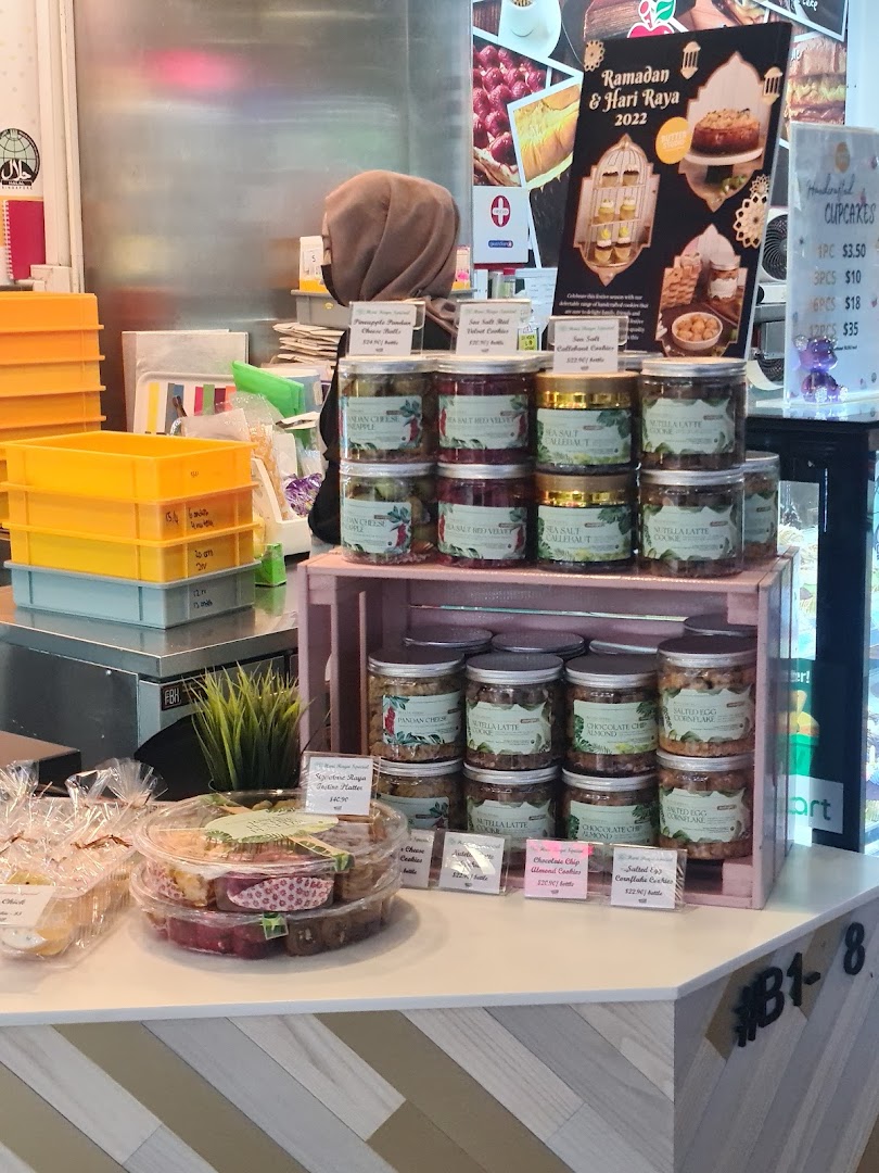 A counter display at Butter Studio featuring various jarred cookies, cupcakes, and festive treats.