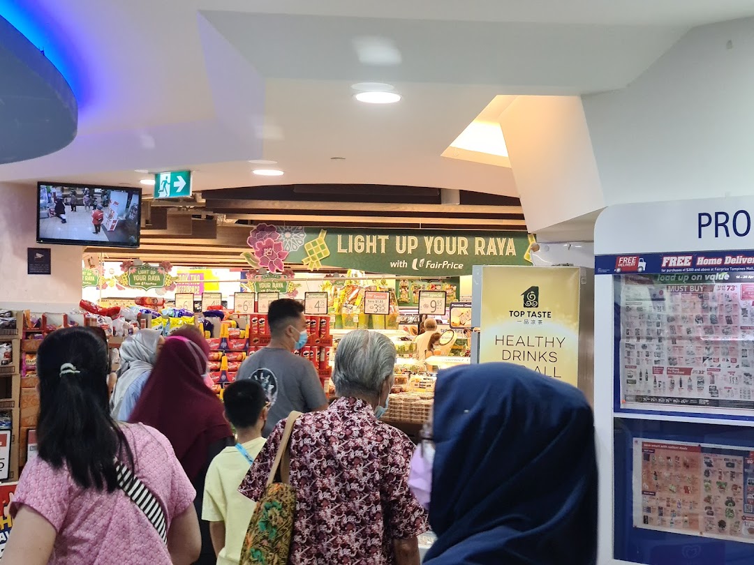 Shoppers browse aisles inside a FairPrice supermarket, featuring promotional displays and products.