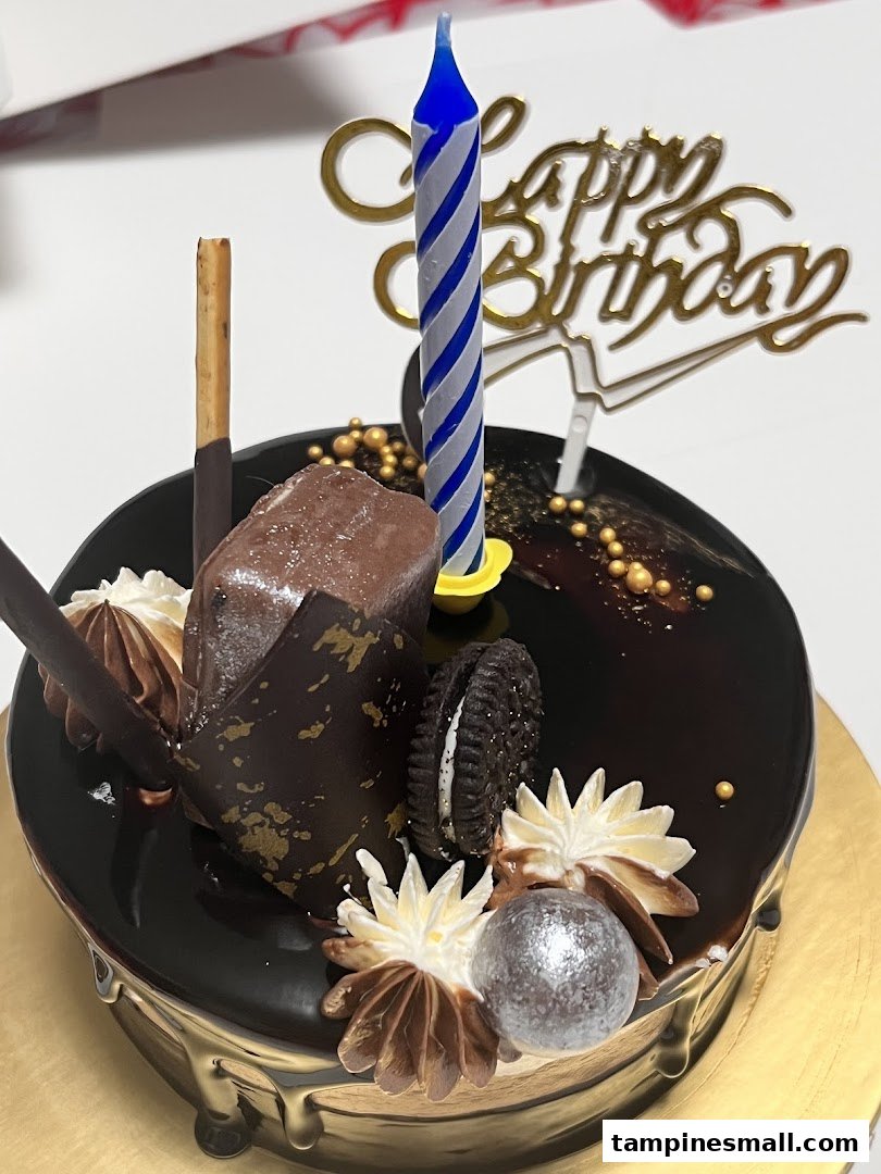 A decadent chocolate birthday cake adorned with various chocolate toppings and a 'Happy Birthday' topper.