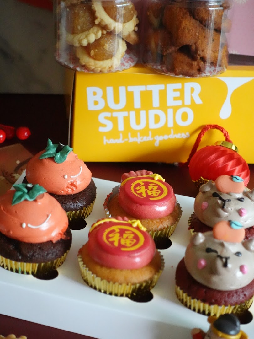 Assorted festive cupcakes and cookies from Butter Studio, featuring unique designs and flavors.