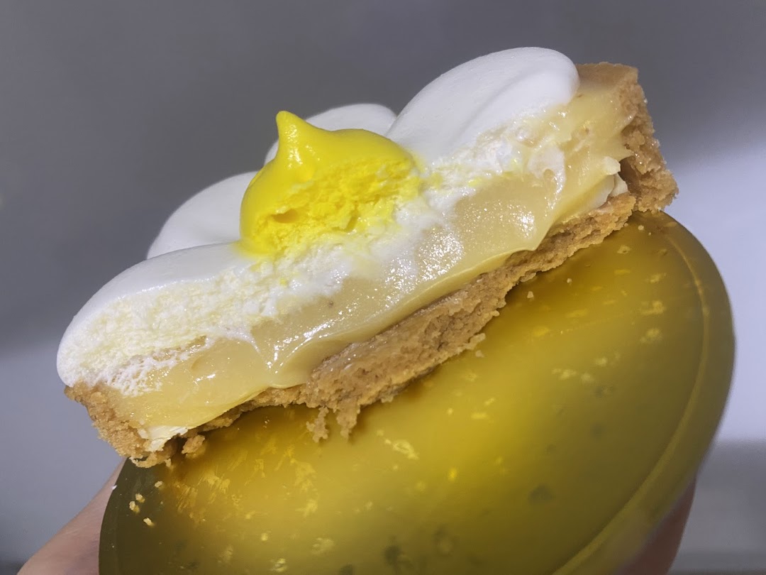 A close-up of a delicious lemon meringue tart with a unique 'fried egg' design.