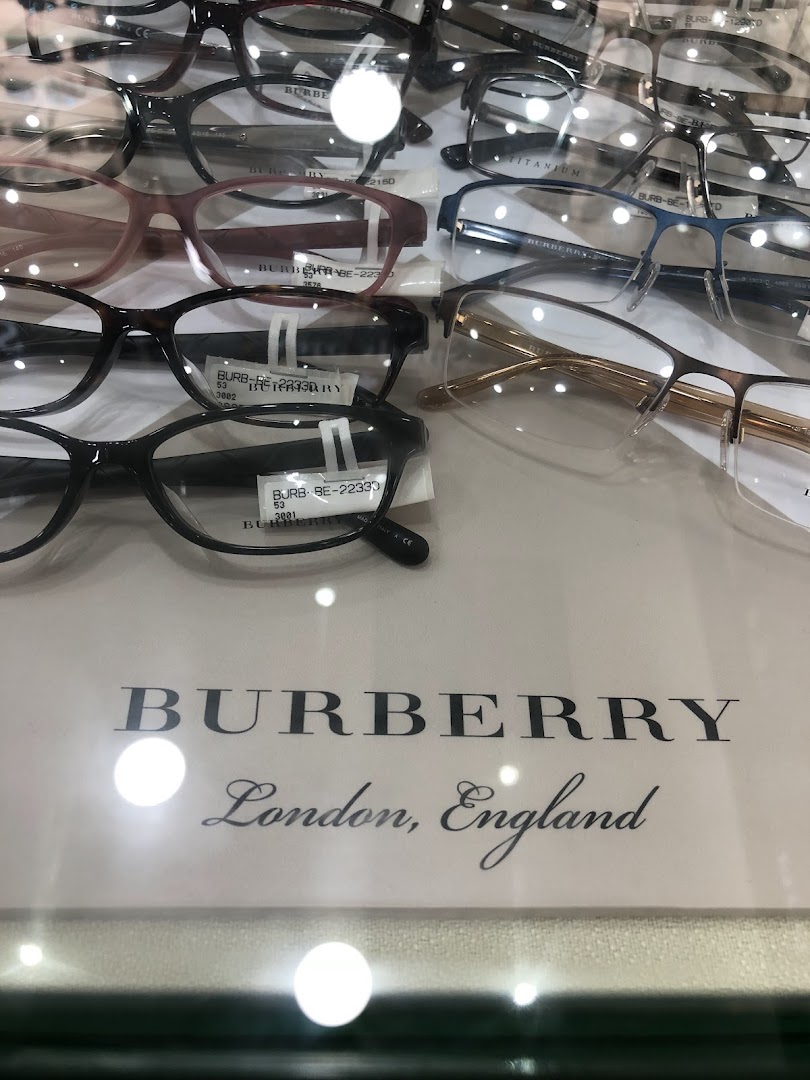A close-up display of various stylish eyeglasses, including Burberry frames, at Capitol Optical.