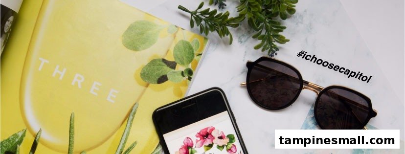 A pair of stylish sunglasses, a smartphone, and a magazine on a marble-patterned surface.