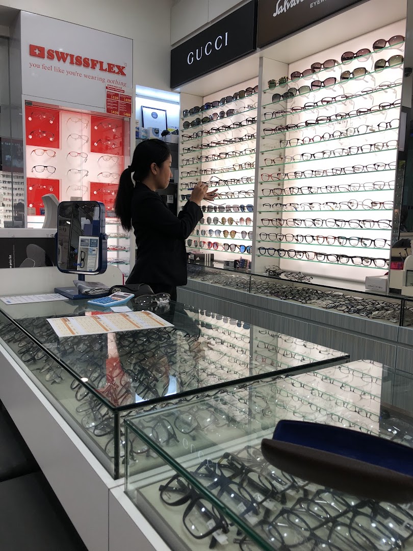 A staff member organizes a wide selection of eyeglasses and sunglasses on display at Capitol Optical.