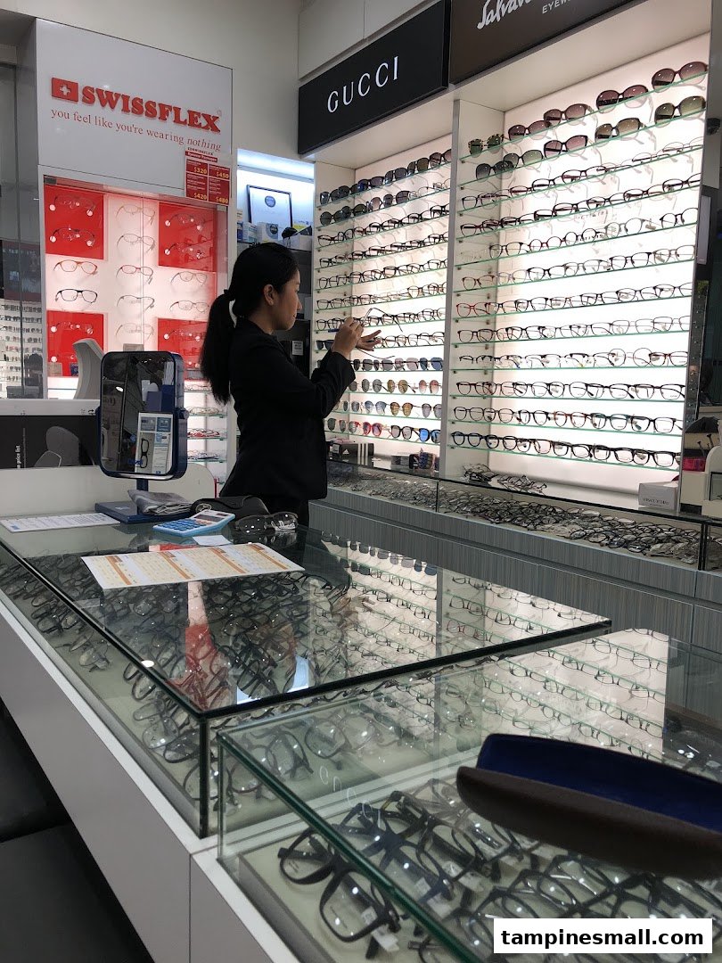 A staff member organizes a wide selection of eyeglasses and sunglasses on display at Capitol Optical.