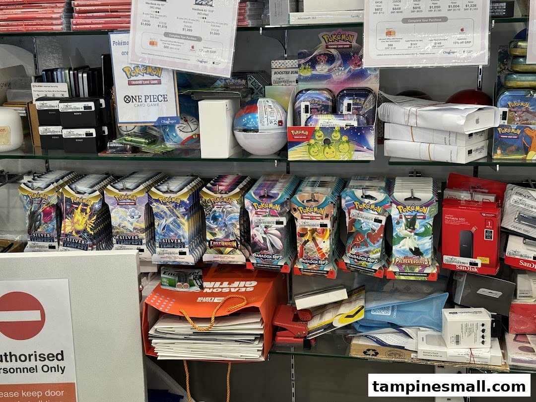 Shelves inside Challenger store displaying Pokémon trading cards, Apple products, and various electronics.