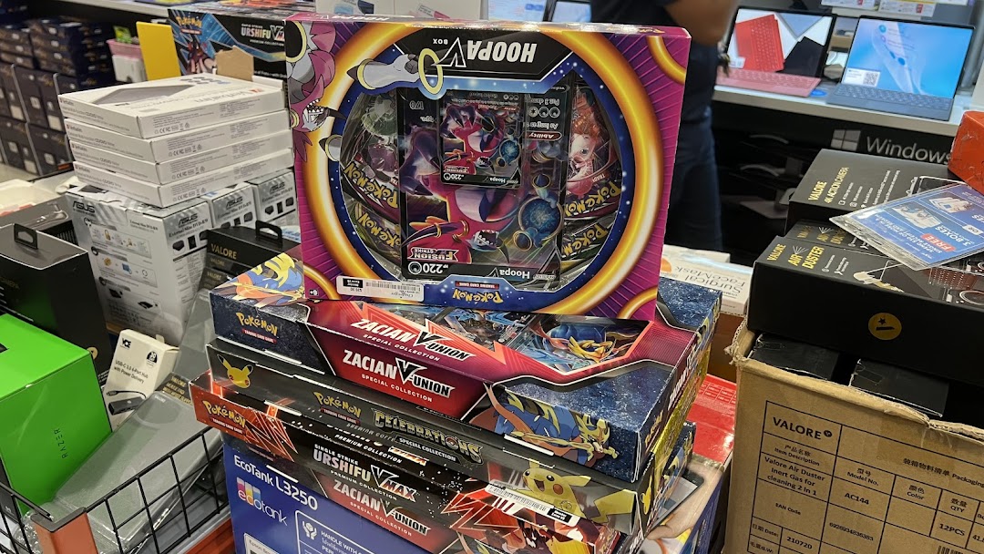 A display of electronics, including Razer products, and various Pokémon Trading Card Game boxes at Challenger.