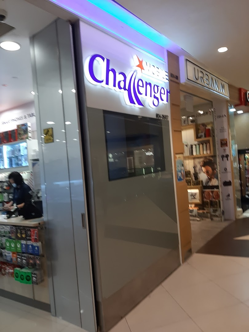 The shopfront of Challenger, an electronics and IT retailer, with its illuminated sign and entrance.