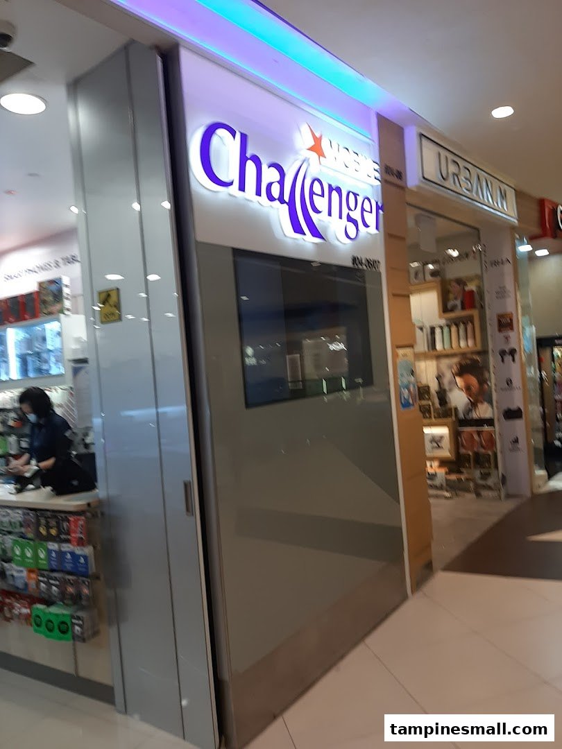 The shopfront of Challenger, an electronics and IT retailer, with its illuminated sign and entrance.