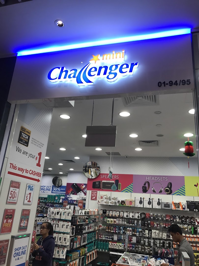 The illuminated entrance of mini Challenger electronics store, showcasing a wide range of tech products inside.