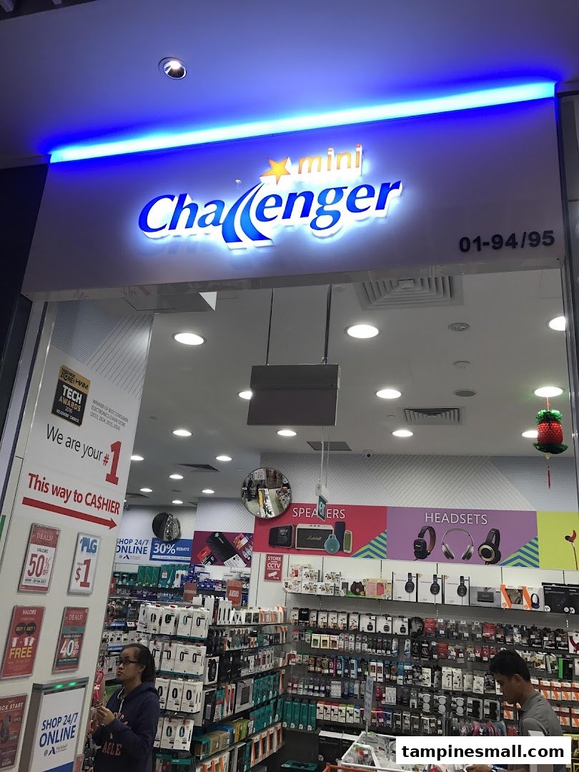 The illuminated entrance of mini Challenger electronics store, showcasing a wide range of tech products inside.