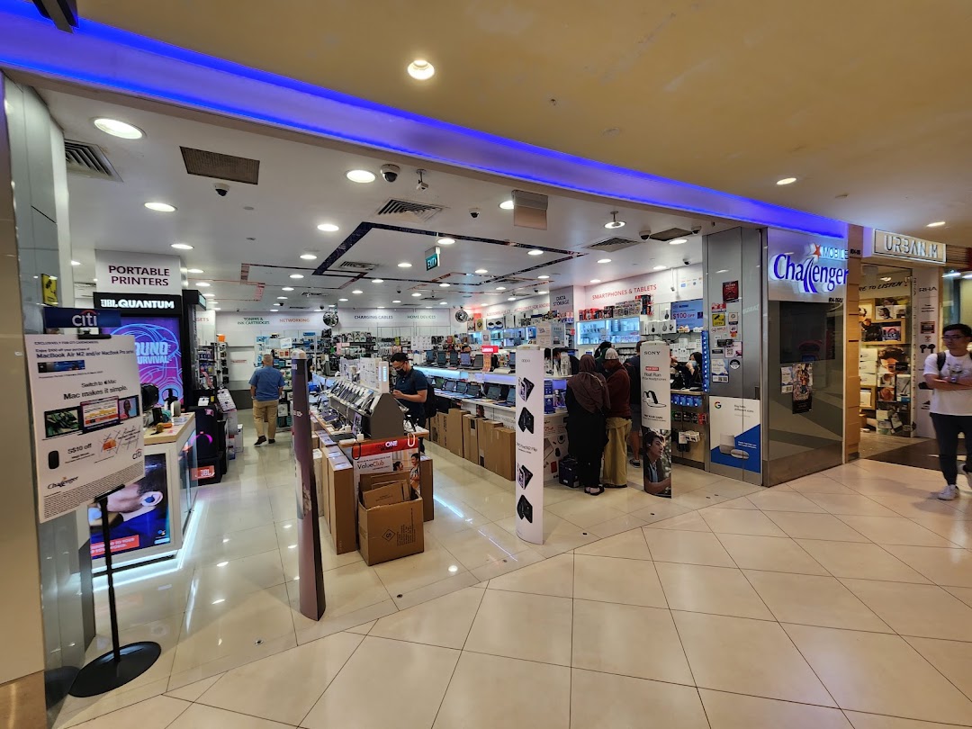Interior view of Challenger electronics store with customers browsing various tech products and displays.