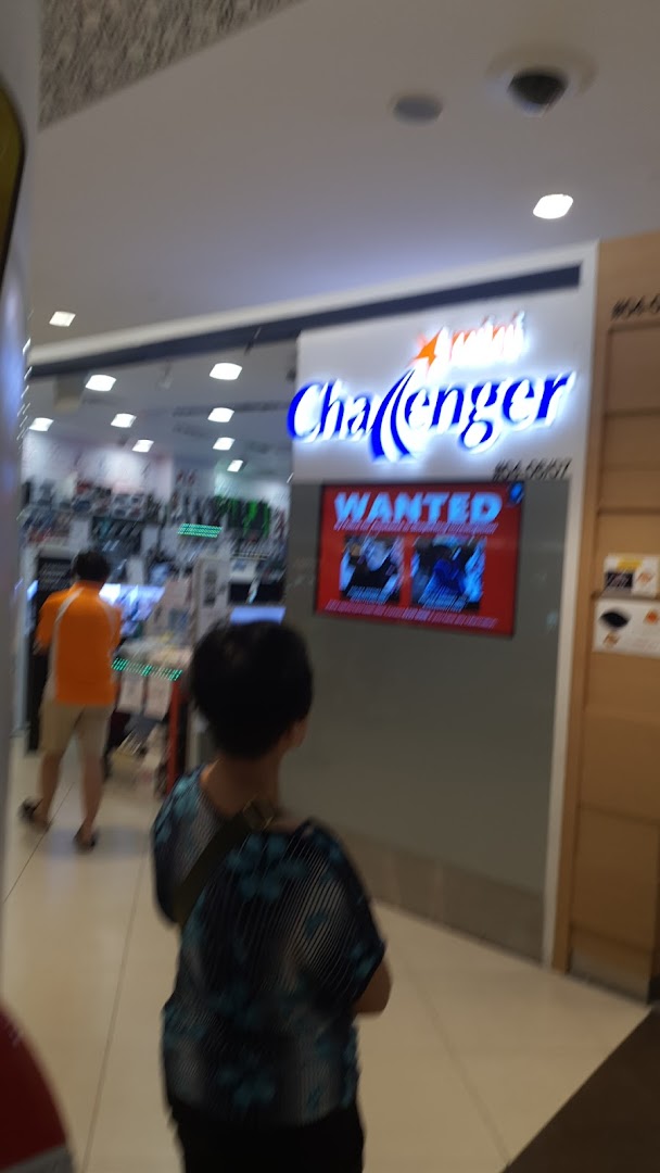 The brightly lit entrance of Challenger Tampines Mall, an electronics store, with customers entering.