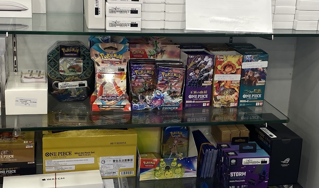 Shelves stocked with Pokémon and One Piece trading card games, alongside other electronics products.