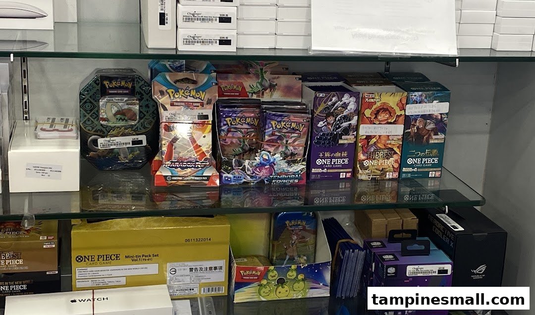 Shelves stocked with Pokémon and One Piece trading card games, alongside other electronics products.