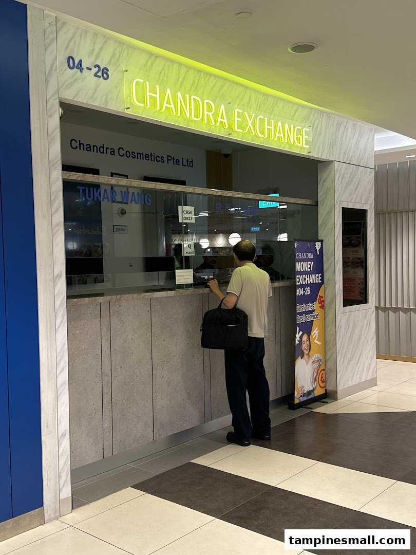 A customer stands at the counter of Chandra Money Exchange, a currency exchange service.