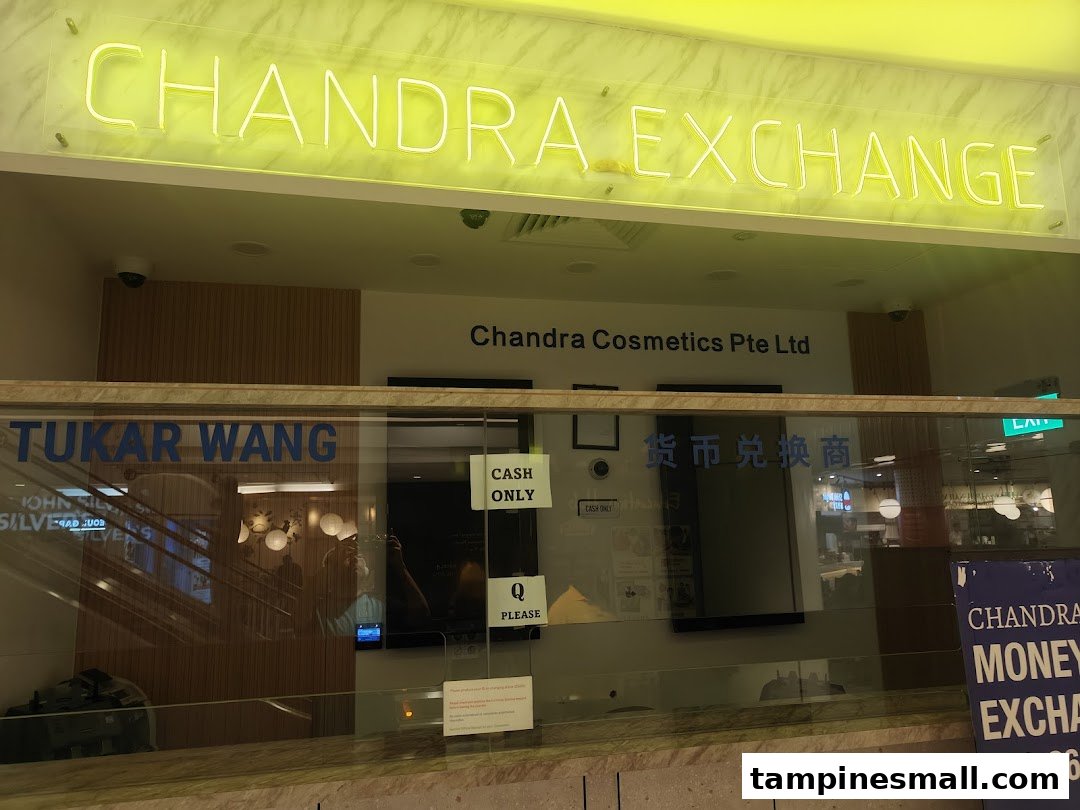 The image shows the brightly lit neon sign and glass facade of Chandra Money Exchange.