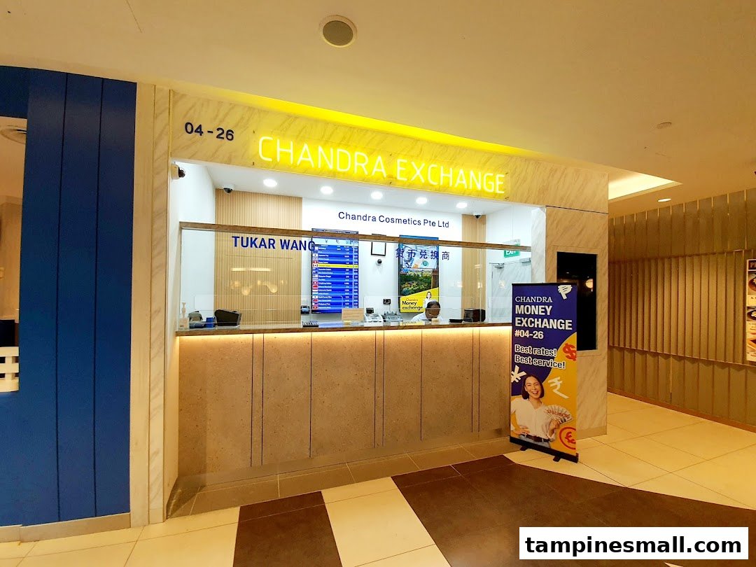 The brightly lit entrance of Chandra Money Exchange, featuring its counter and signage.