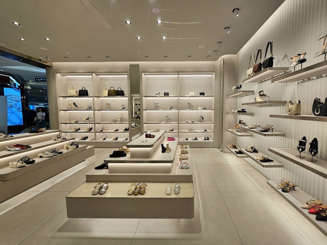 An elegant interior view of CHARLES & KEITH, showcasing a wide array of stylish shoes and handbags on illuminated displays.