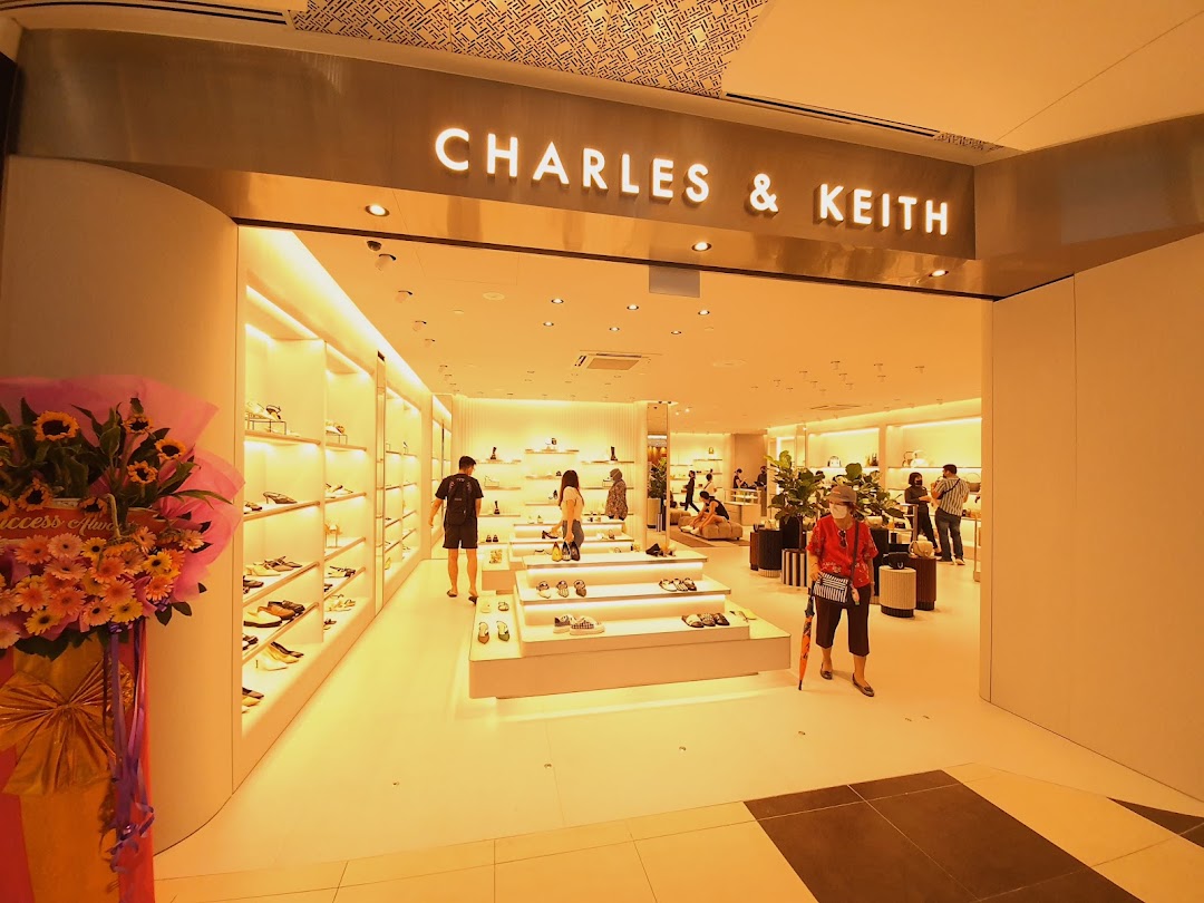 The CHARLES & KEITH shop entrance features a brightly lit interior showcasing shoes and accessories, with customers browsing.