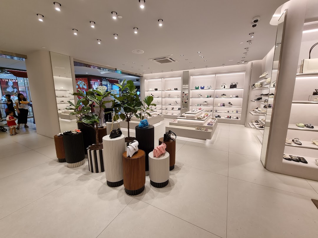 An interior view of a CHARLES & KEITH store, showcasing shoes and handbags on modern displays.