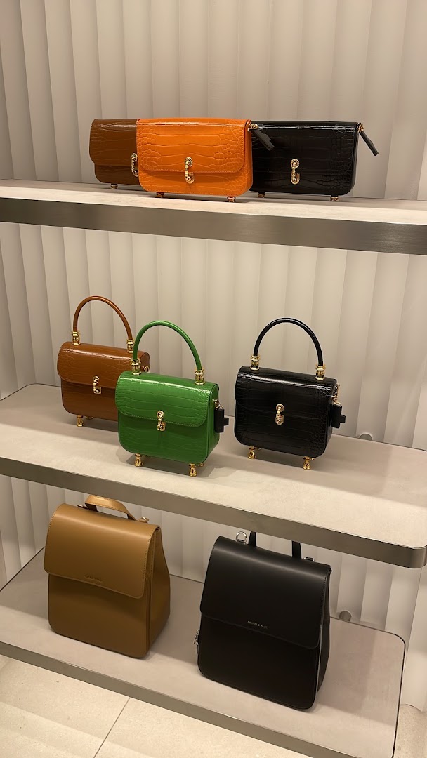 Stylish handbags and backpacks from CHARLES & KEITH displayed on shelves.