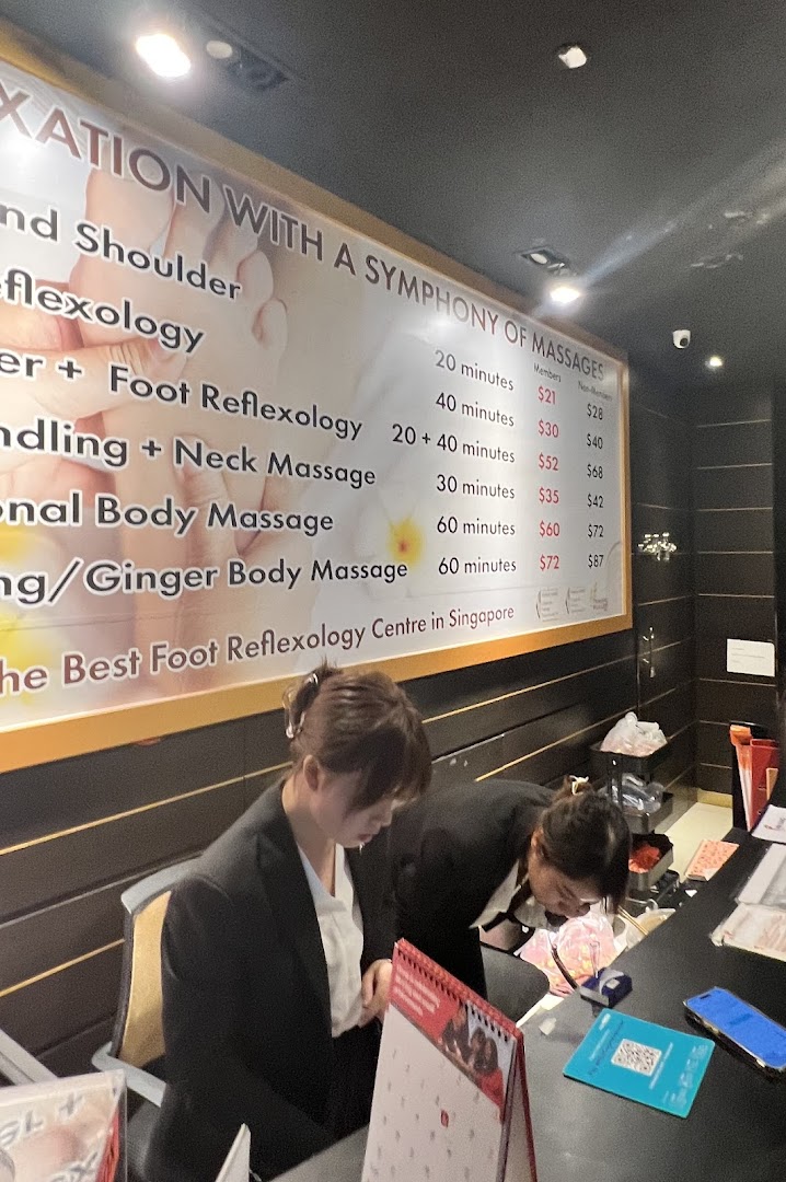 A large price list for various massage and reflexology services at Chen Kang Wellness, with staff at the counter.