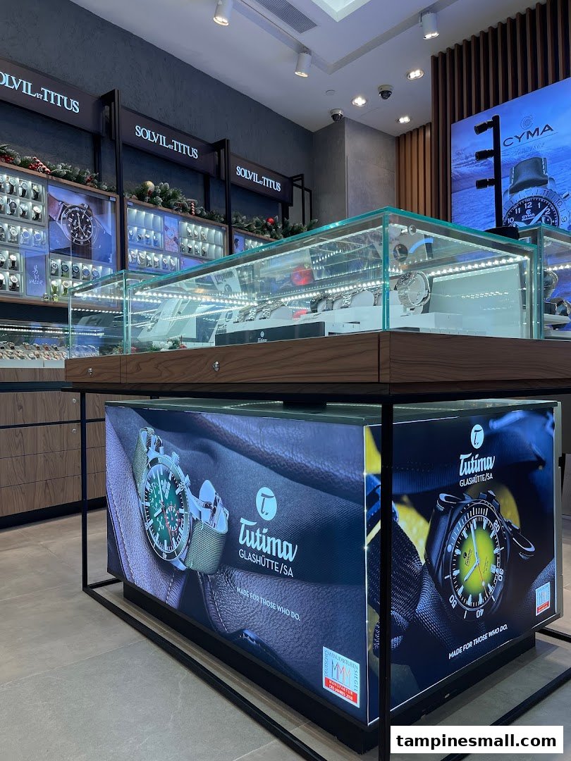 Interior view of a watch shop featuring display cases with various timepieces and brand promotions.