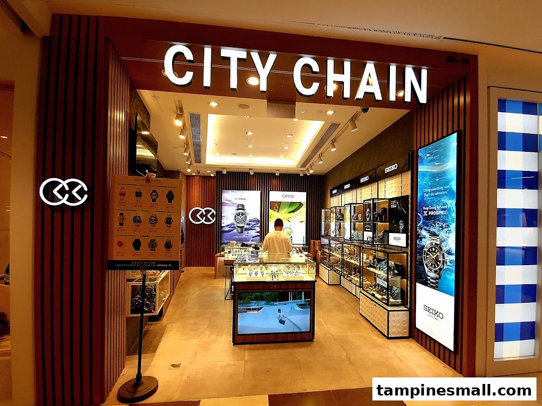 The brightly lit entrance of City Chain, a watch and eyewear store, with display cases and a staff member inside.