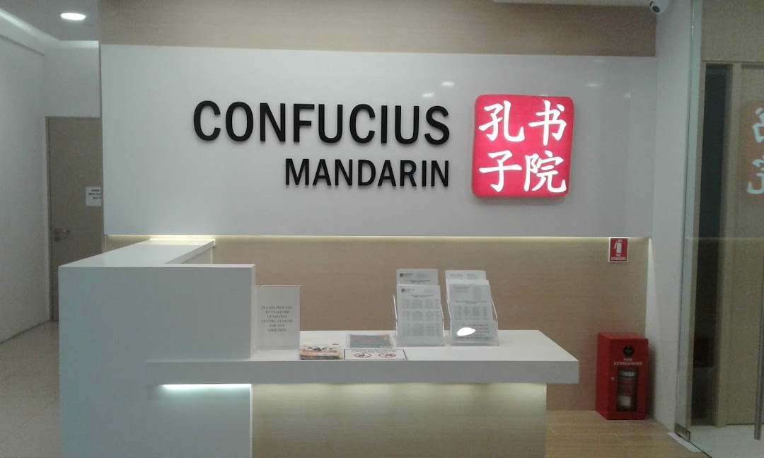 The bright and modern reception area of Confucius Mandarin, featuring a prominent logo and desk.