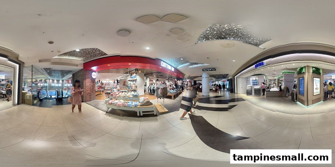 The vibrant entrance of Cotton On Tampines, showcasing fashion displays and shoppers within a bustling mall.