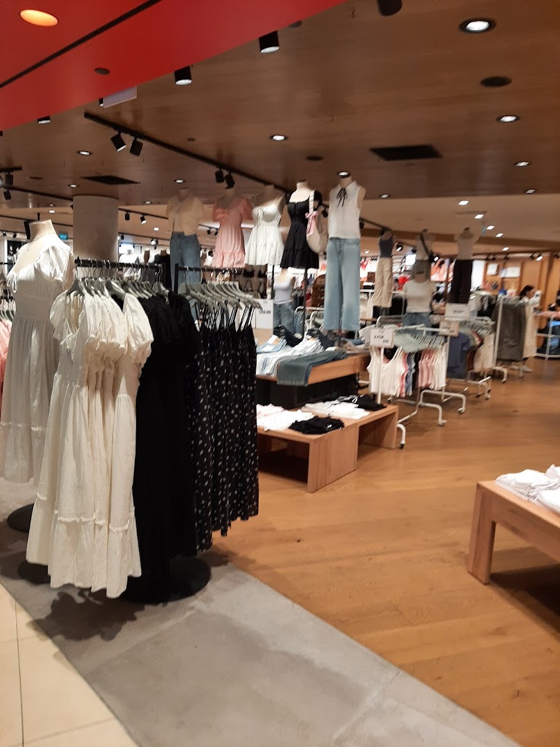 Interior view of Cotton On Tampines, showcasing various clothing items on mannequins and racks.