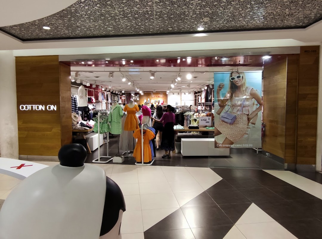 The shop front of Cotton On, showcasing its vibrant interior with clothing displays and mannequins.