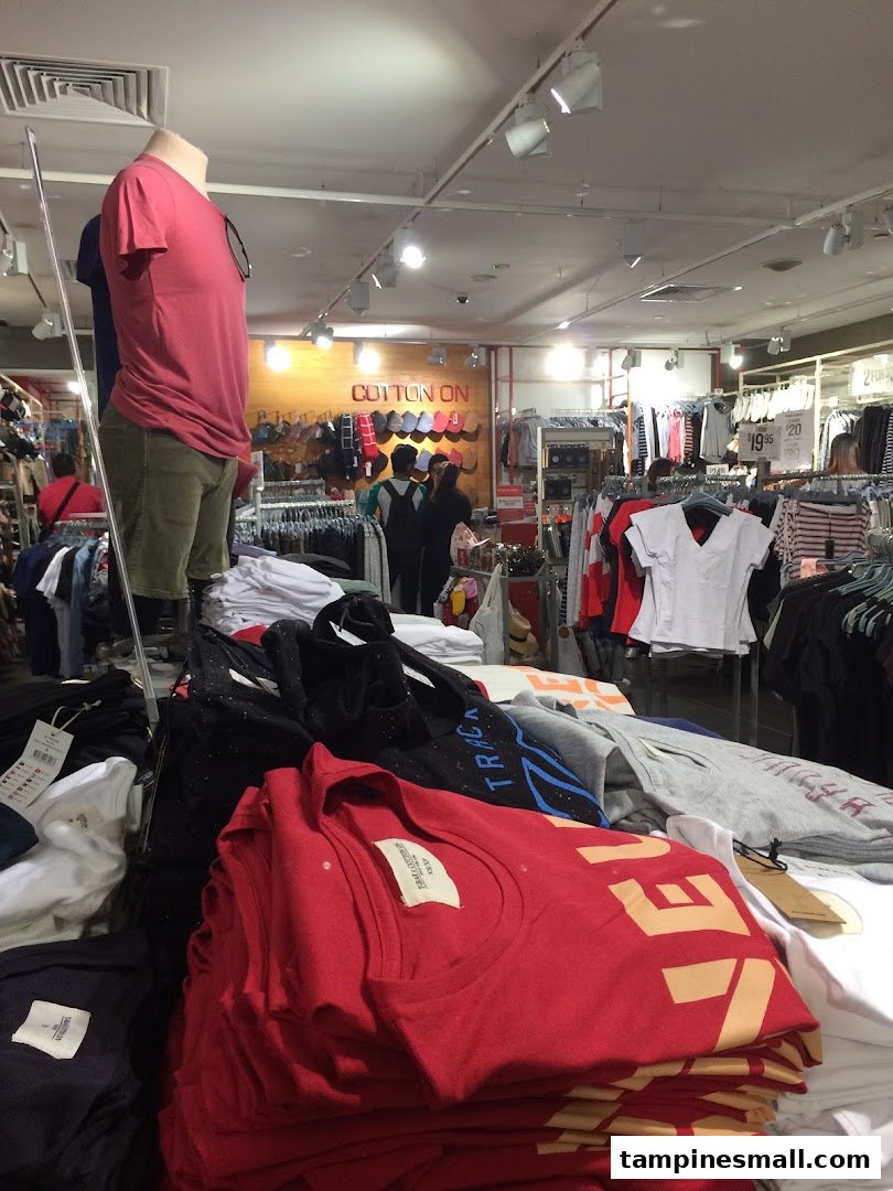 An interior view of Cotton On, showcasing clothing displays, mannequins, and customers browsing apparel.
