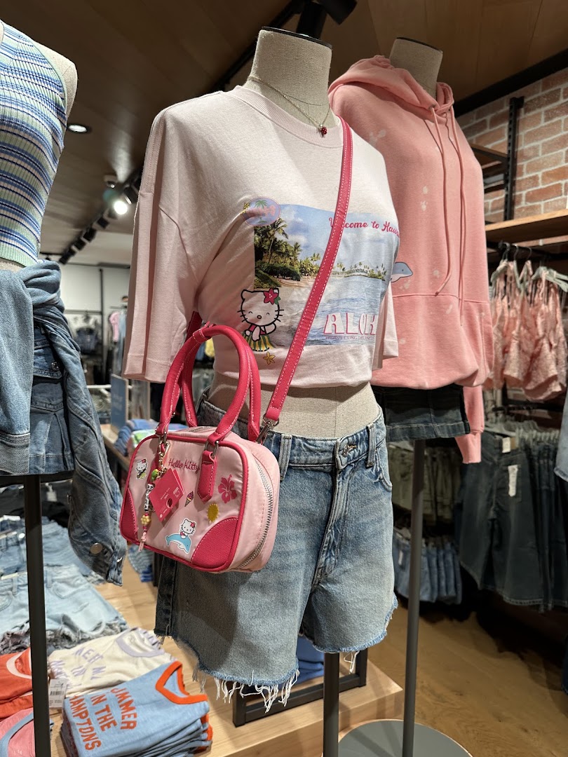 Mannequins display trendy casual wear, including a Hello Kitty t-shirt and pink handbag, inside Cotton On.