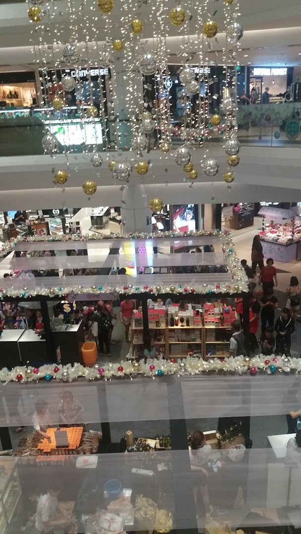 An overhead view of a bustling multi-level shopping mall interior adorned with festive holiday decorations.