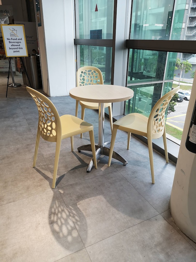 A cozy seating area with a round table and three chairs next to a large window.