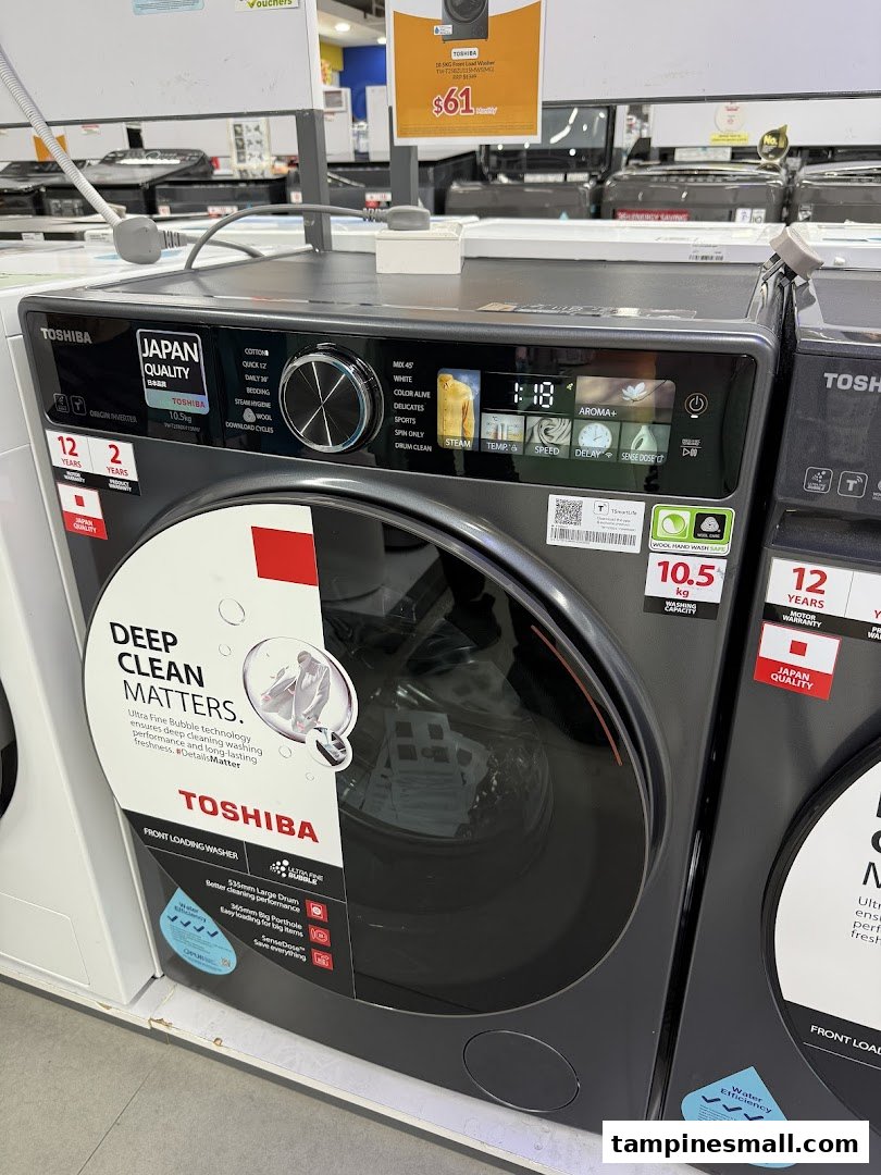 A Toshiba front-loading washing machine on display at COURTS, showcasing its features and a promotional price.