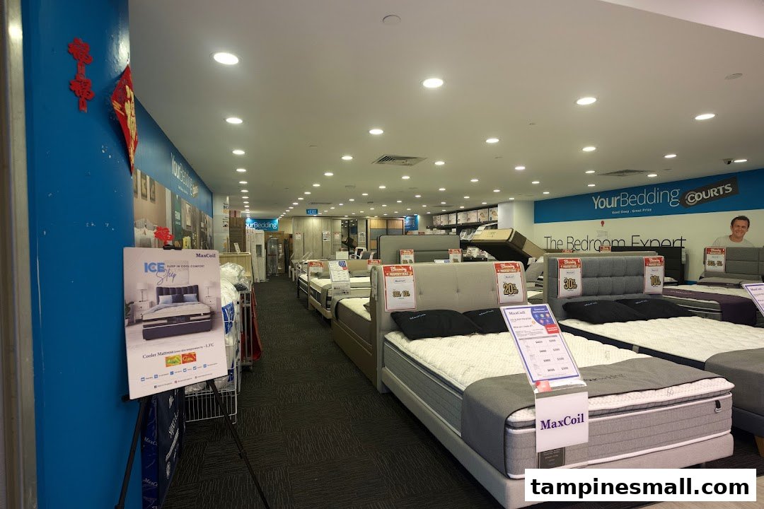 An interior view of COURTS Tampines Mall's bedding section, showcasing various mattresses and bed frames.