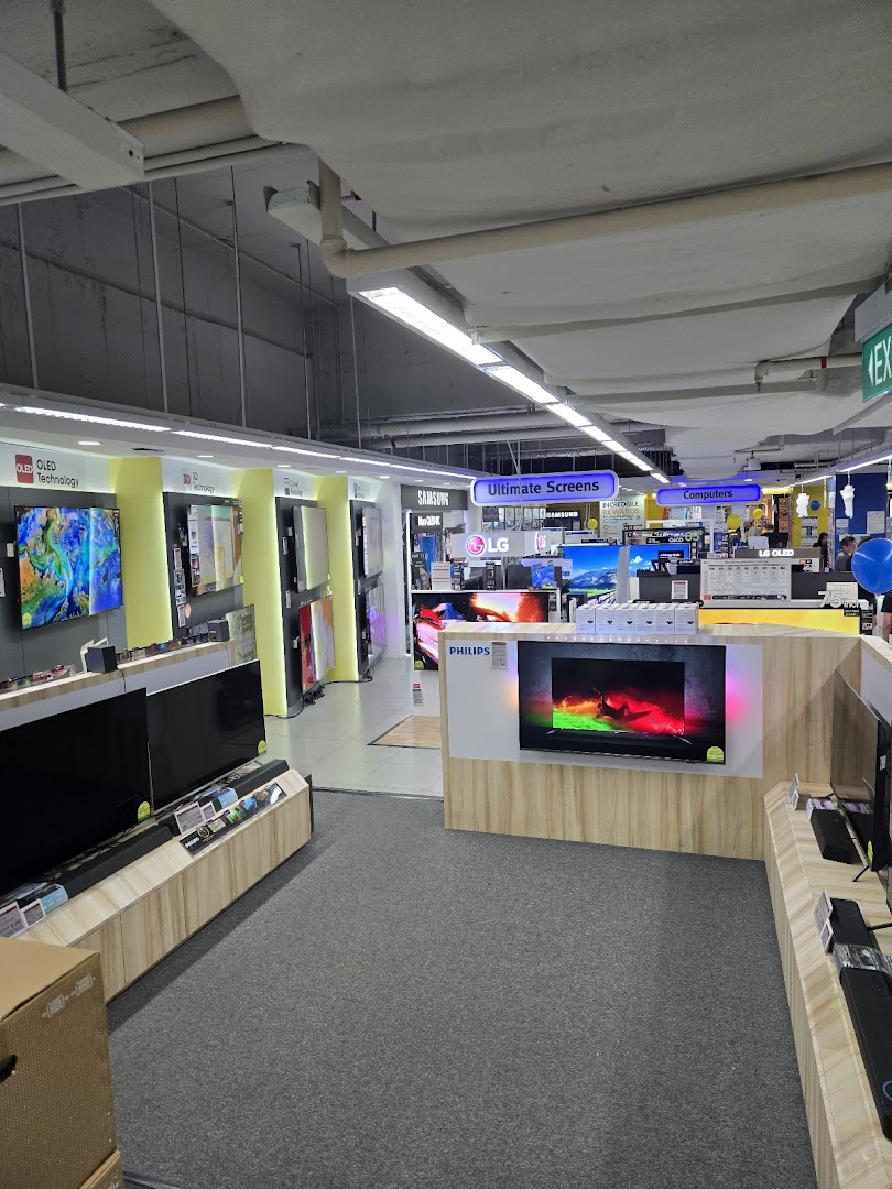 Interior view of COURTS electronics store showcasing a wide array of TVs and computer displays.