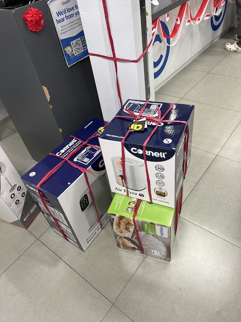 Various boxed home appliances, including Cornell air fryers and a Philips rice cooker, tied with red ribbons.