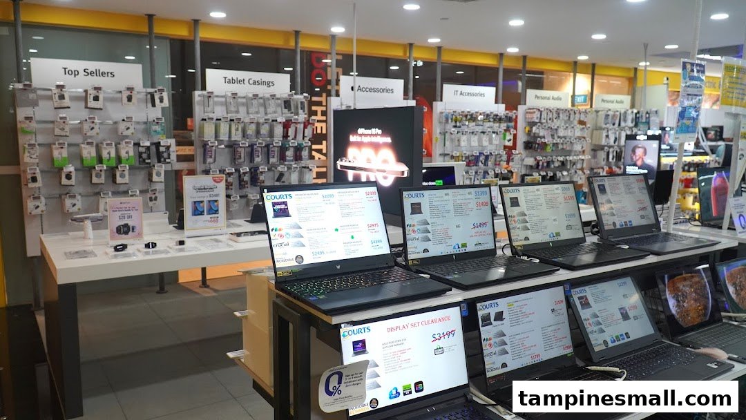 Interior view of COURTS electronics store, showcasing laptops, accessories, and various tech products.