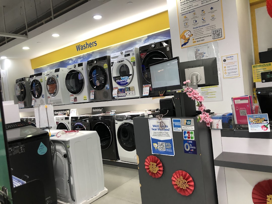 Interior view of COURTS showcasing a wide range of washing machines and a customer service counter.
