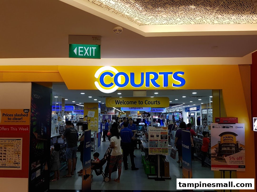 The vibrant entrance of COURTS Tampines Mall, showcasing electronics and home appliances, bustling with shoppers.