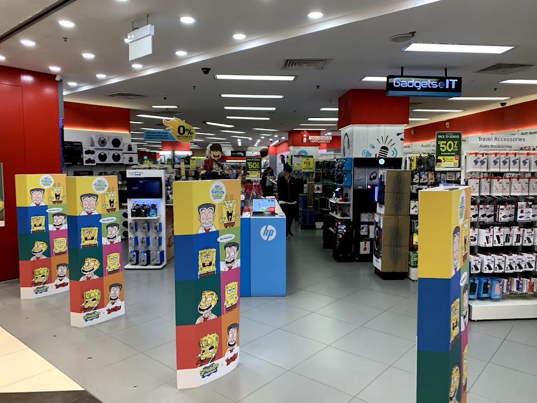 An interior view of COURTS Tampines Mall, showcasing various electronics, gadgets, and accessories sections.