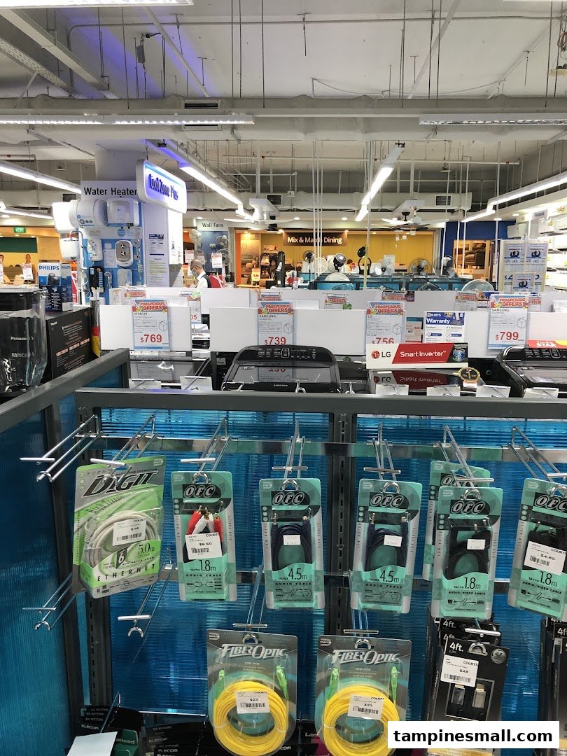 An interior view of COURTS Tampines Mall, showcasing various home appliances, electronics, and cables.