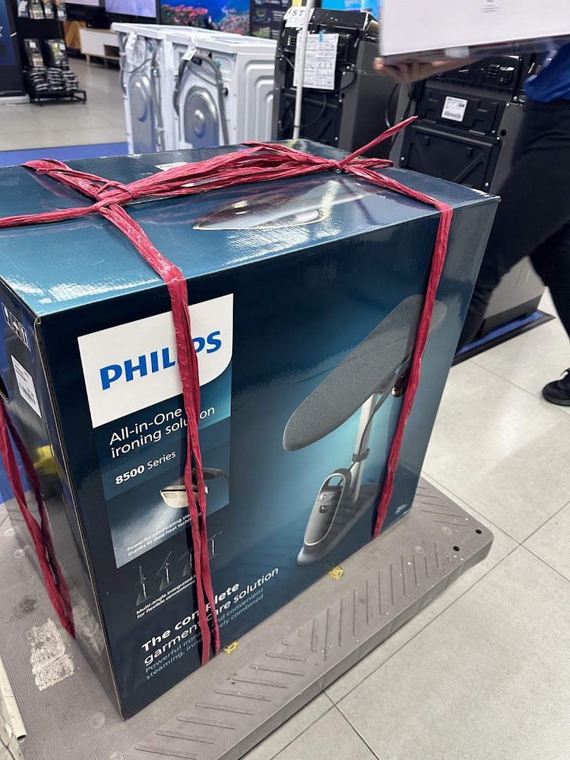 A Philips All-in-One ironing solution box on a trolley, ready for transport inside COURTS.