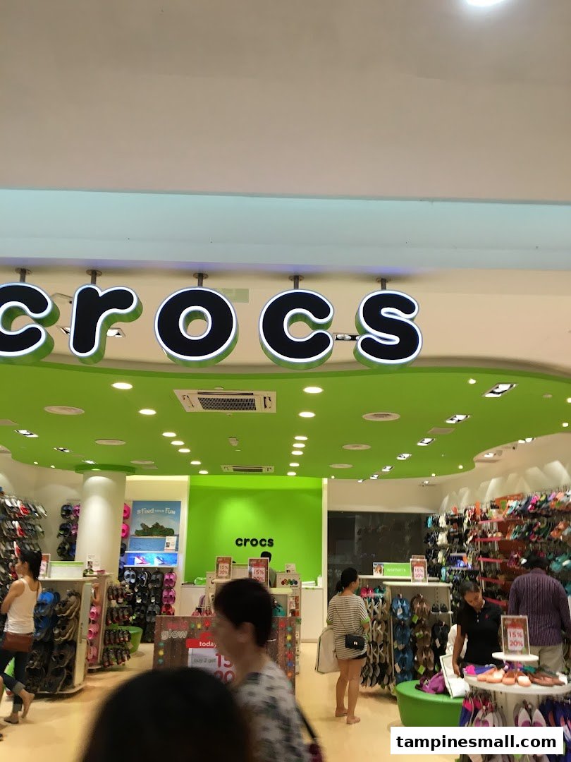 Vibrant Crocs store interior with customers browsing colorful footwear and prominent brand signage.