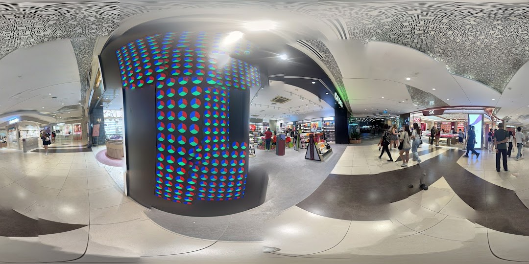 A panoramic view of a bustling shopping mall interior featuring the Crocs store and other retail outlets.